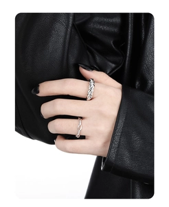 Detailed view of sterling silver twisted rope and infinity rings on a model hand
