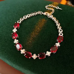 Elegant silver bracelet featuring ruby-red oval stones and white floral zirconia accents