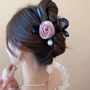 Detailed back view of a black hair claw with pink fabric rose, ribbon, and pearl pendant