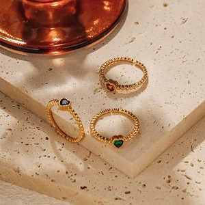 Detailed macro view of three 18K gold plated heart zircon rings with bead texture