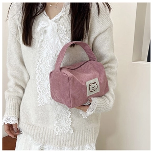 Detail of lavender corduroy square bag featuring cute embroidered cartoon bear patch
