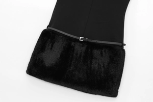 Detail of black dress featuring faux fur trim and thin leather belt with metal buckle