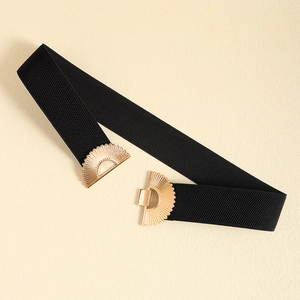 Detail of black elastic belt featuring a golden fan-shaped interlocking metal buckle