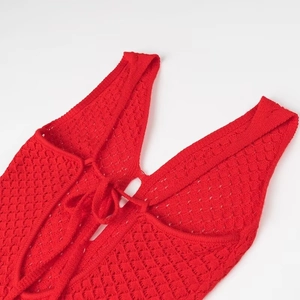 Gros plan du décolleté en V en maille rouge avec détails de bretelles et texture