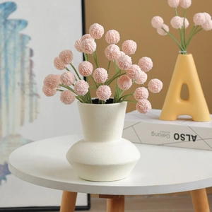 Pink billy balls artificial flowers in minimalist beige ceramic vase for home decor