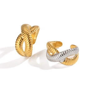 Detailed view of twisted crisscross rings with gold ribbed texture and dual-tone finish