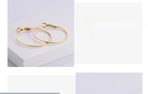 Detail of 18k gold plated hoop earrings with embossed square line texture and lever back