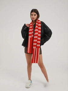 Close-up of the soft knitted texture and red-pink striped pattern of the winter scarf