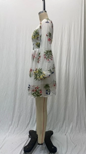 Detail von weißen Netz-Laternenärmeln mit aufwendiger bunter Blumenstickerei am Mini-Kleid