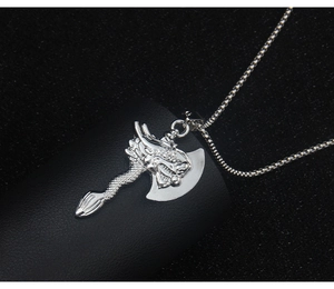 Close-up of silver Viking dragon axe pendant with box chain on black textured surface