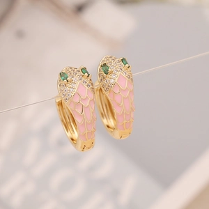 Macro detail of snake-shaped earrings with pink enamel scales and green gemstone eyes