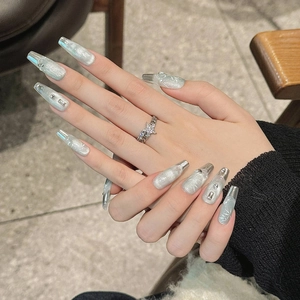 Handcrafted silver cat-eye press-on nails with white leaf patterns and long trapezoid shape