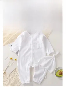 Close-up of ribbed cotton baby romper and matching knotted hat on cozy knit blanket