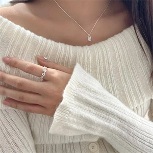 Detail of 925 sterling silver padlock necklace and hollow chain ring on model