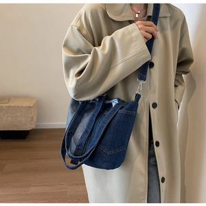 Detailed view of dark blue denim bucket bag with adjustable strap and carry handle