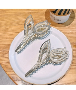 Detailed view of luxury tulip hair claws with pearls and rhinestones on a white plate