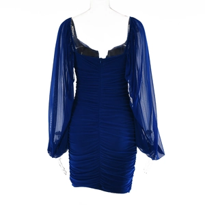 Detail of ruched deep blue mini dress featuring sheer mesh sleeves and back zipper closure