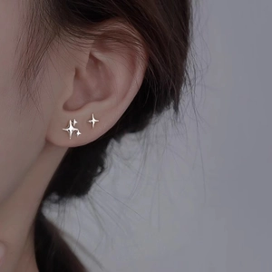 Macro shot of a minimalist 925 silver star stud earring worn on the earlobe
