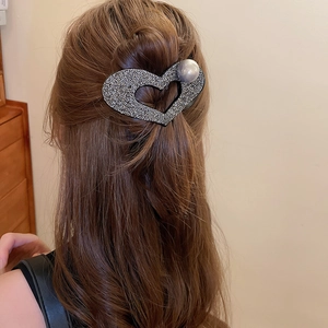 Detail view of heart hair claw with pearls and rhinestones on hair back profile