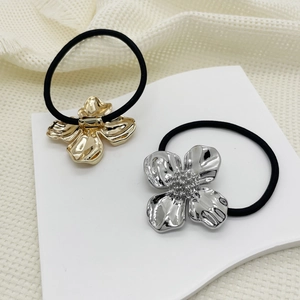 Close-up of gold and silver metal flower hair ties with rhinestones and black elastic band