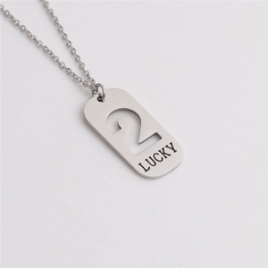 Macro shot of a silver titanium steel pendant with hollow number 2 and LUCKY engraving