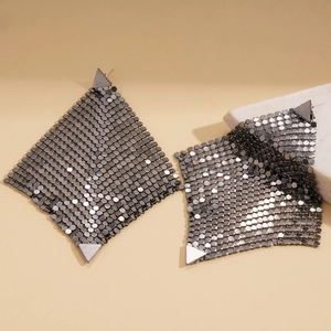 Close-up of geometric gunmetal mesh earrings with triangular metallic scale texture