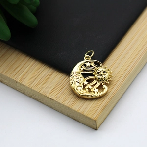 Macro detail of 18K gold plated sun moon and star pendant on a bamboo jewelry tray