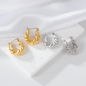 Boucles d'oreilles créoles torsadées dorées et argentées sur tissu en soie