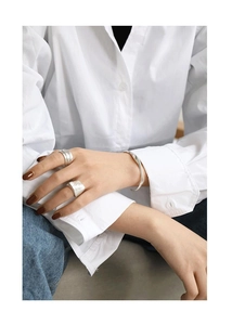 Close-up of S925 sterling silver cuff bracelet and irregular textured rings on model