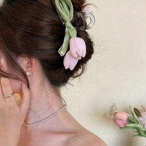 Pink tulip fabric hair claw clip worn by a model in a sweet and elegant style