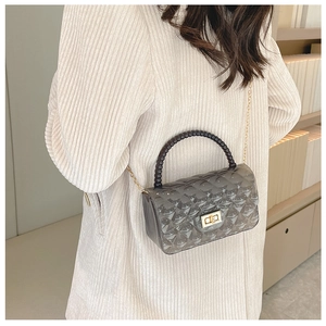 Detail of grey transparent jelly bag with black bead handle and gold chain strap
