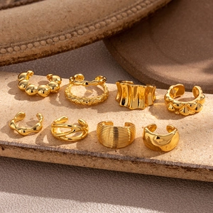 Detailliertes 8er-Set goldene Ohrmanschetten mit Texturen auf einem Steinständer