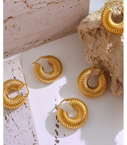 Detail of 18K gold plated hoop earrings with textured spiral design on stone