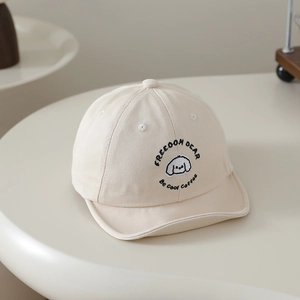 Vue détaillée de la casquette bébé crème avec broderie chien mignonne et texte