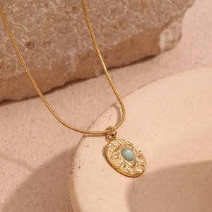 Detail of 18K gold-plated snake chain and hammered oval pendant with light blue amazonite