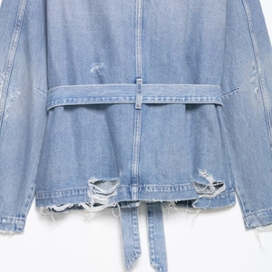 Vintage light blue denim jacket for women featuring adjustable belt and distressed details