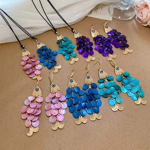Detail of colorful fish-shaped shell necklaces and earrings set with gold metal frames