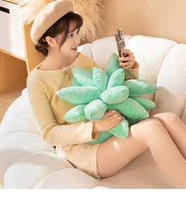 Young woman on sofa holding a soft green succulent plant plush toy pillow for decoration