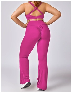 Detail view of rose pink high-stretch yoga set featuring cross-back bra and flared leggings