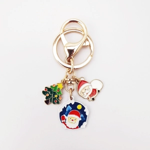 Detailed close-up of alloy Christmas keychain with enamel Santa and tree charms