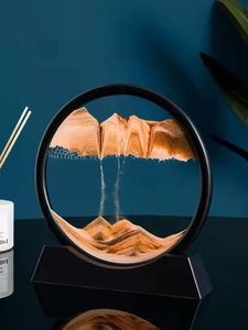 Macro detail of round orange sand art landscape with black frame and liquid reflection