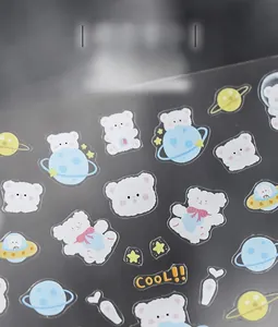 Macro detail of cartoon space bear nail art stickers with blue planets and cute icons