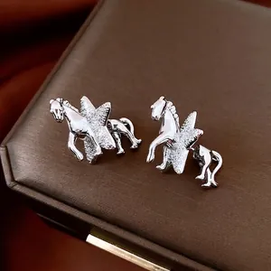 Silver horse and star stud earrings with sparkling zircons on a luxury brown gift box