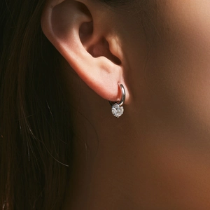 Minimalist 925 sterling silver 1ct moissanite hoop earring worn by a model on ear