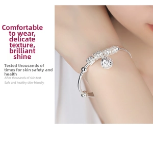 Detail view of silver-plated bracelet with hollow bells and lucky beads on a wrist
