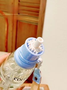 Detail of blue portable water bottle featuring detachable straw and adjustable strap