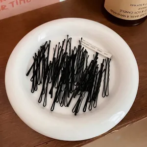 Lot de barrettes à cheveux noires minimalistes avec design ondulé dans un plat