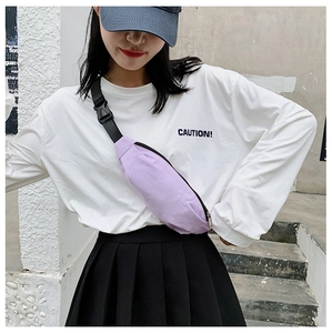 Close-up of a light purple canvas waist bag worn by a model in a minimalist urban setting