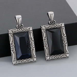 Vue macro de pendentifs vintage en acier inoxydable avec pierres noires facettées