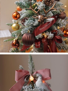 Detail of Christmas tree decorations with bronze reindeer head and red satin ribbon